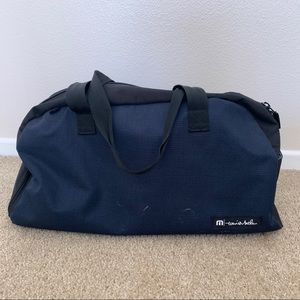 Travis Mathew navy blue and black duffel bag
